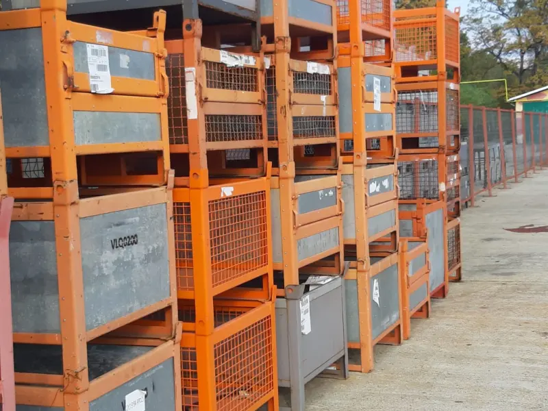 Conteneurs métalliques orange empilés dans une zone de stockage extérieure